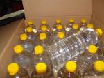 Plastikowe butelki z żółtym korkiem, wypełnione bezbarwną cieczą.