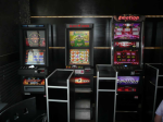 Trzy automaty do gier hazardowych stoją w pomieszczeniu. . 