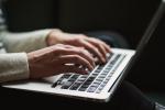 Dłonie kobiety piszące na klawiaturze laptopa