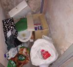 Wnętrze toalety z porzuconymi na podłodze torbami z papierosami.