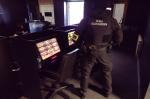 Funkcjonariusz Służby Celno-skarbowej ogląda nielegalne automaty do gier hazardowych. 