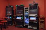 Automaty do gier hazardowych stojące pod ścianą w pomieszczeniu.  