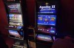 dwa automaty do gier hazardowych stojące pod ścianą w pomieszczeniu.  