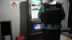 Funkcjonariusz stoi przed automatem hazardowym.