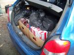 Zdjęcie papierosów w kartonowych pudłach i czarne worki ukryte w bagażniku samochodu